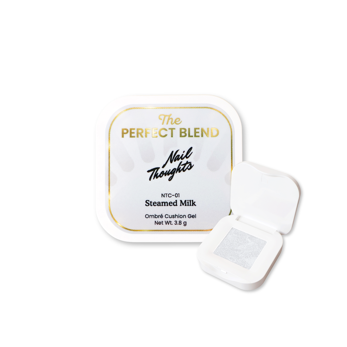 A white nail cushion gel compact with a square lid labeled 'The Perfect Blend' and 'Steamed Milk' by Nail Thoughts, shown next to an open compact revealing a light silver-gray gel powder, on a white background.